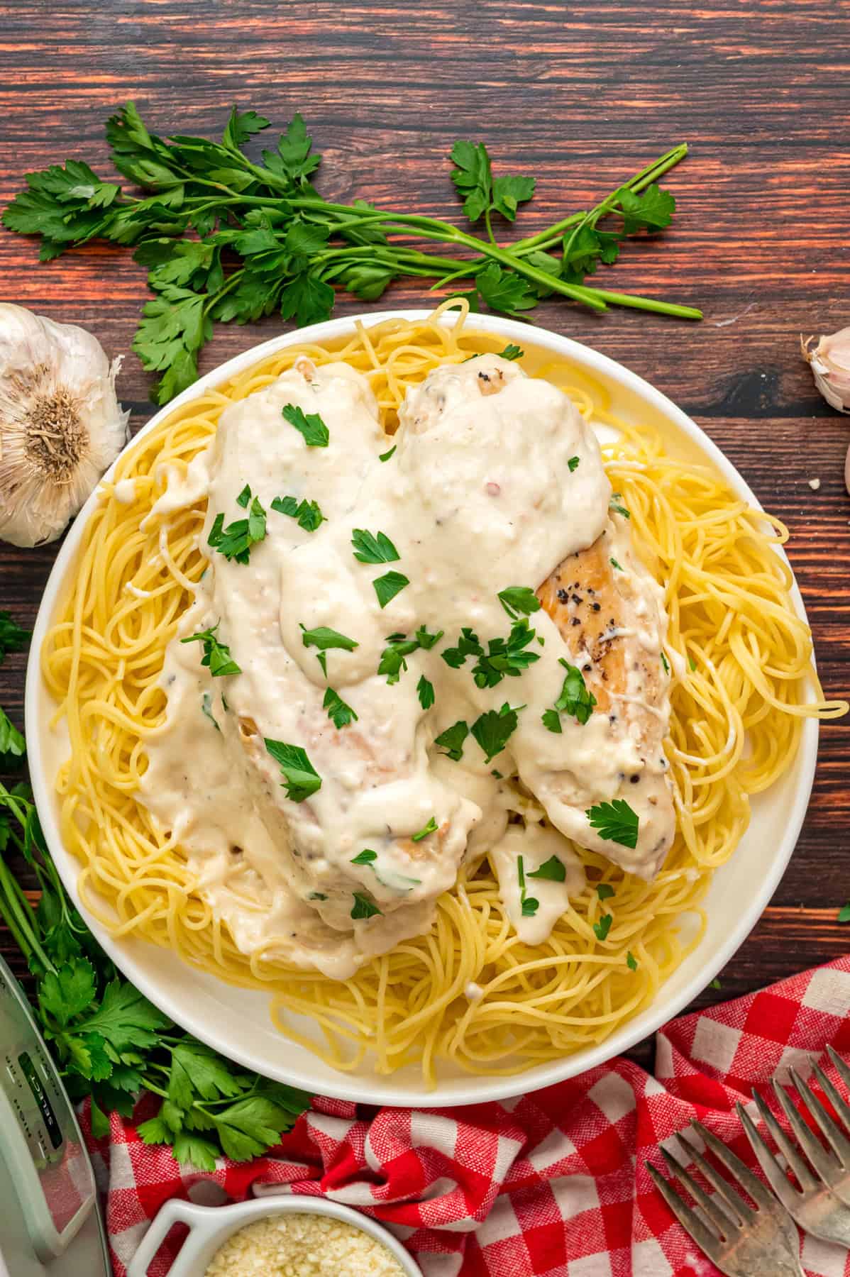 Chicken breasts are slow-cooked in a creamy sauce and served over pasta in this Angel Chicken recipe. A family favorite! Overhead view of a plate of angel chicken pasta