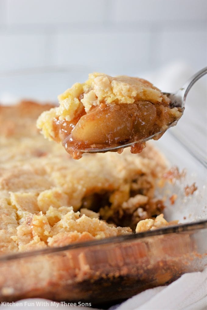 lifting a spoonful of Caramel Apple Dump Cake.