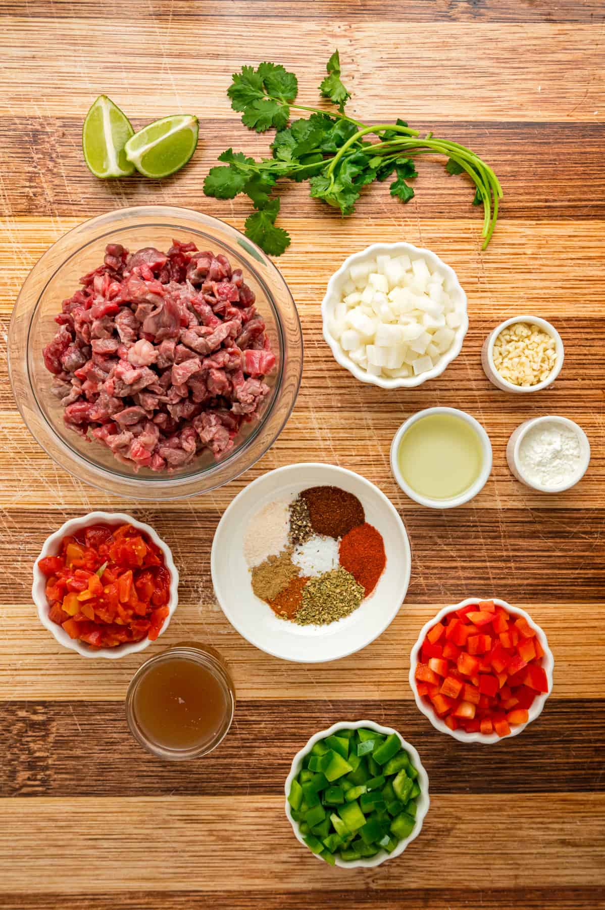 This Carne Picada recipe features braised beef and veggies in a rich, savory sauce. Serve with rice and beans or in tacos and burrito bowls. Overhead view of ingredients needed to make carne picada