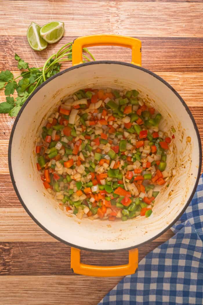 This Carne Picada recipe features braised beef and veggies in a rich, savory sauce. Serve with rice and beans or in tacos and burrito bowls. Bell peppers and onions in a Dutch oven