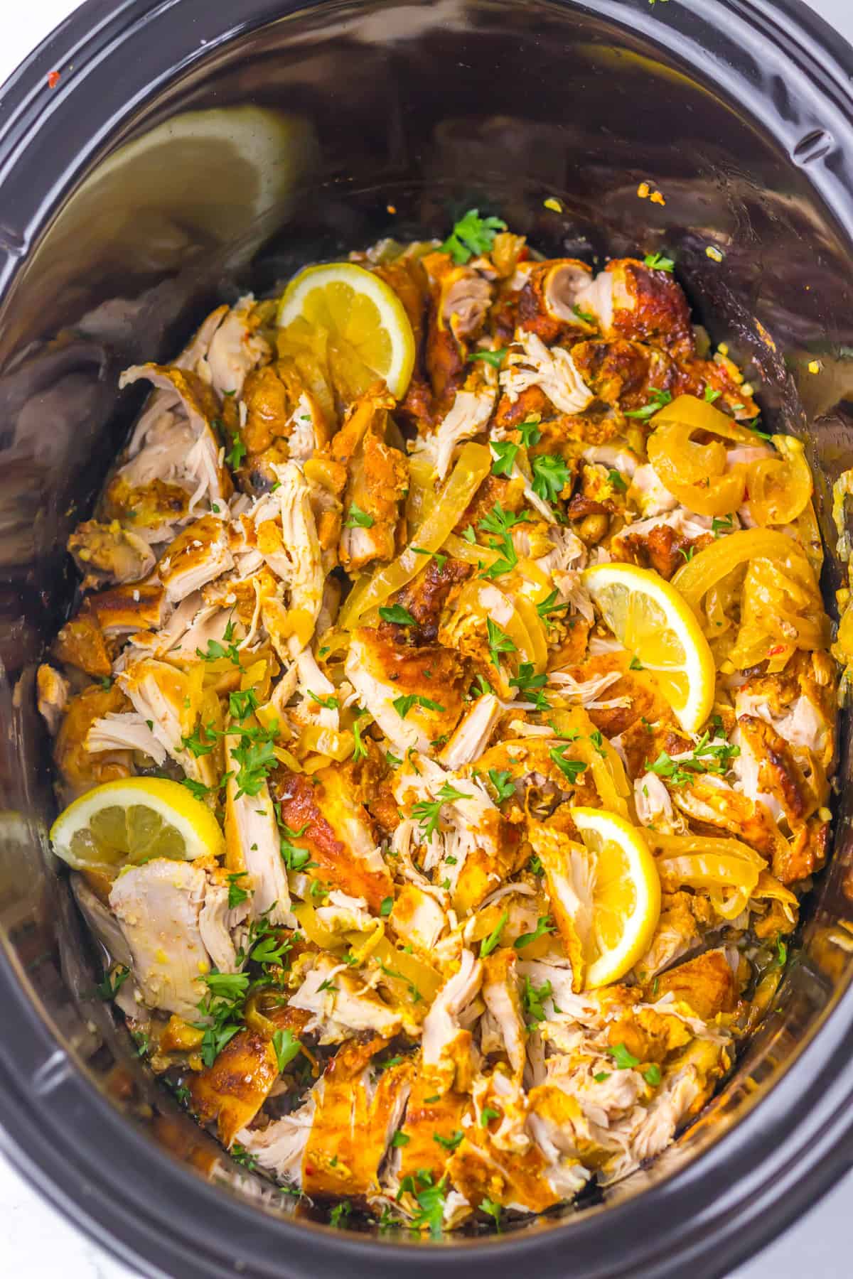 Marinated chicken thighs slow cook until tender in this Chicken Shawarma recipe. Serve piled high on pita with veggies & yogurt sauce. Overhead view of slow cooker chicken shawarma