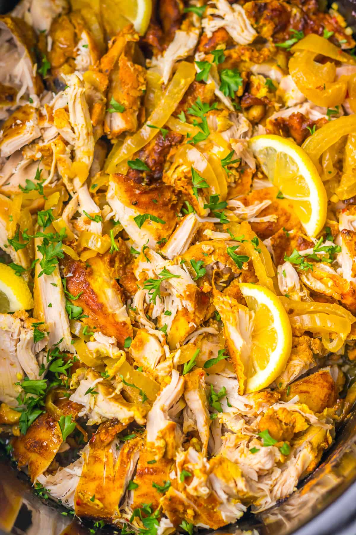 Marinated chicken thighs slow cook until tender in this Chicken Shawarma recipe. Serve piled high on pita with veggies & yogurt sauce. Overhead view of slow cooker chicken shawarma