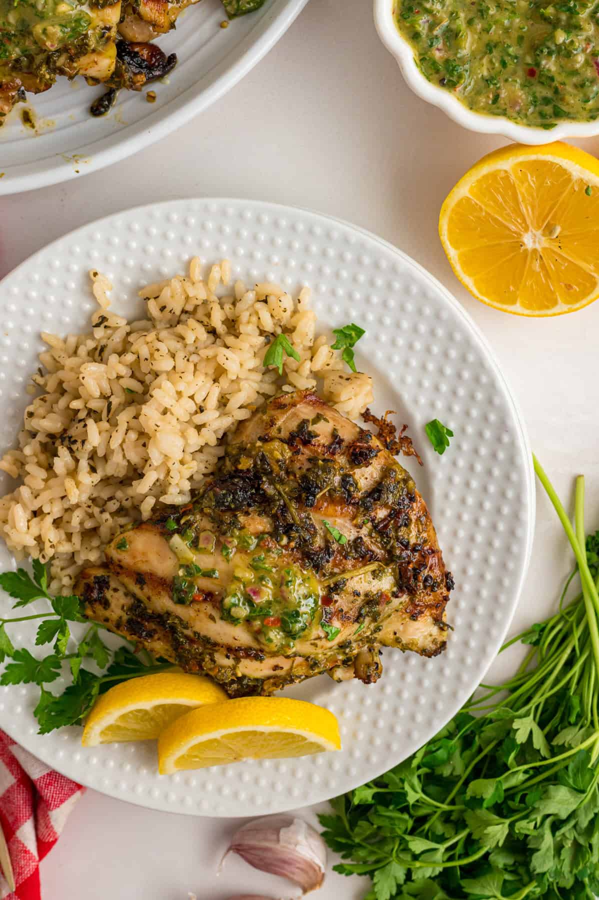 Chicken thighs are marinated in a chimichurri sauce then cooked to tender, juicy perfection in this Chimichurri Chicken recipe. Overhead view of a plate of chimichurri chicken