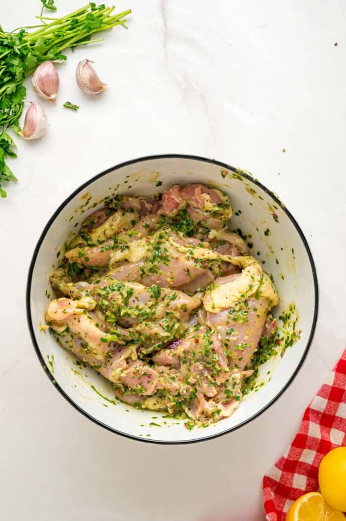 Chicken thighs are marinated in a chimichurri sauce then cooked to tender, juicy perfection in this Chimichurri Chicken recipe. Chicken thighs marinating in chimichurri sauce