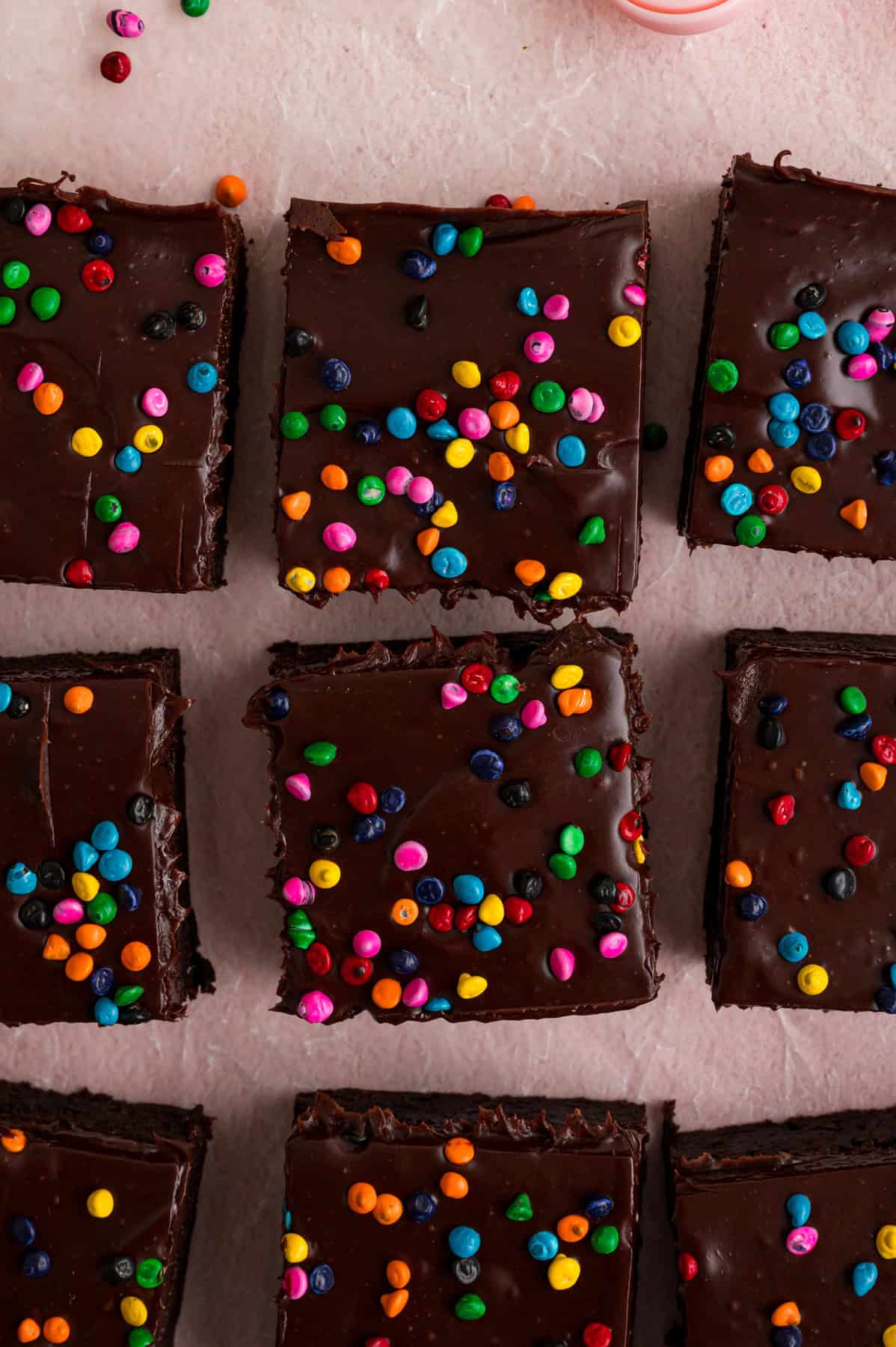With dense, chewy brownies topped with frosting and rainbow candy-coated chocolate chips, these Cosmic Brownies are a nostalgic treat. Overhead view of homemade cosmic brownies