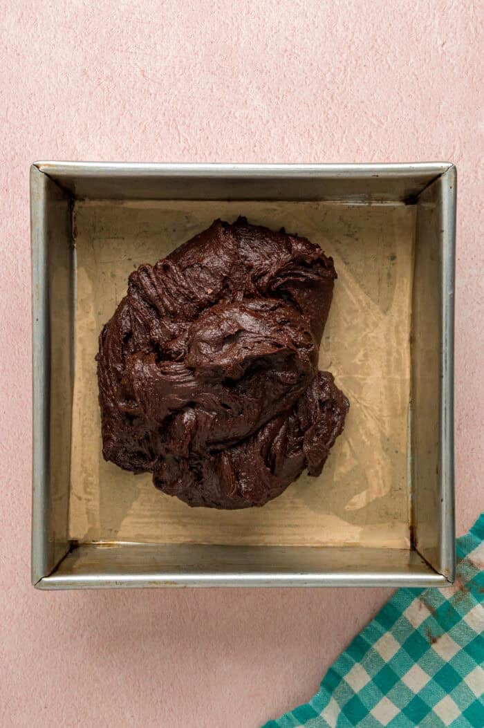 With dense, chewy brownies topped with frosting and rainbow candy-coated chocolate chips, these Cosmic Brownies are a nostalgic treat. Brownie batter in a square pan