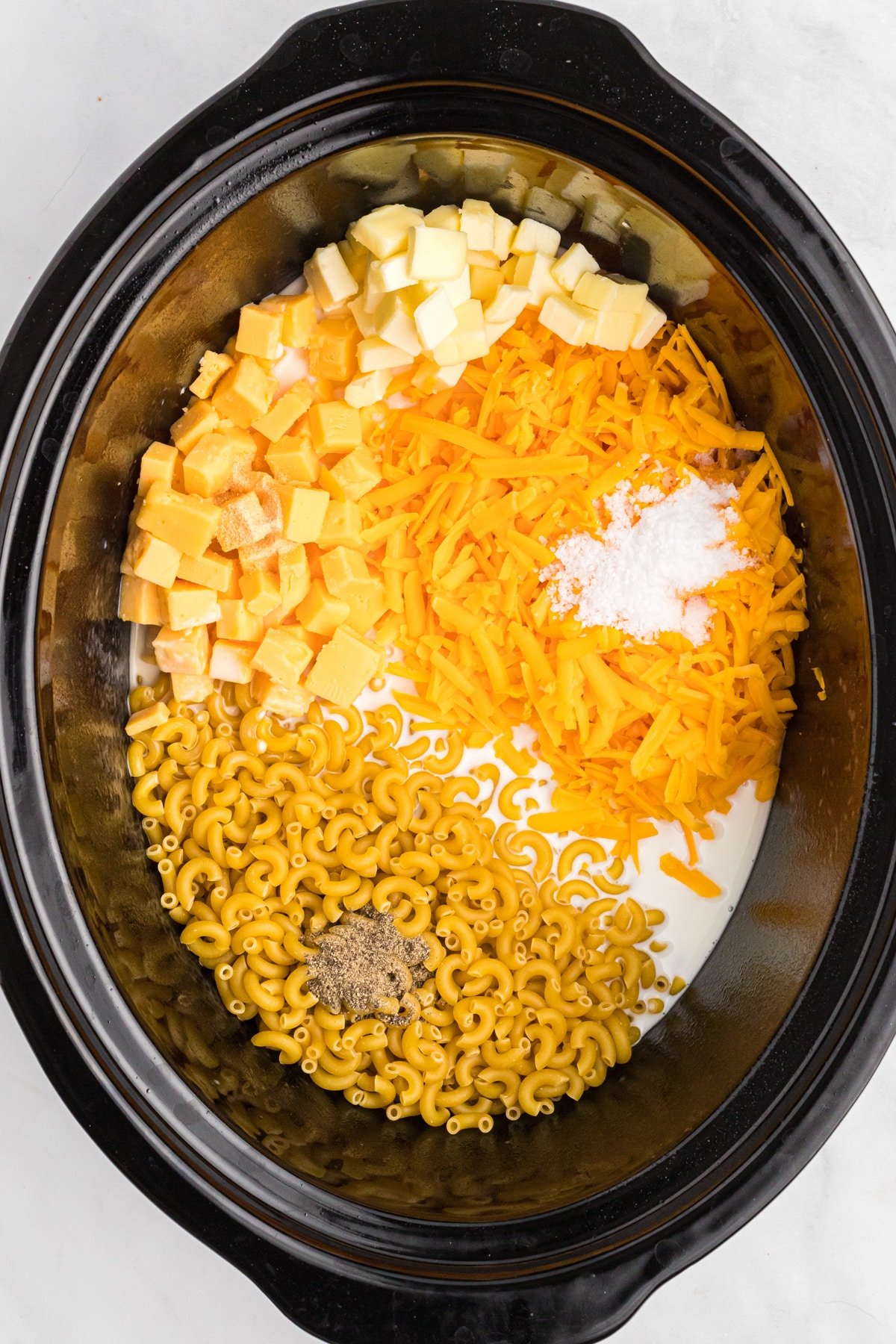 Made with a mix of cheddar and American cheeses, this Crock Pot Mac and Cheese is uber creamy and super easy to make. Crockpot mac and cheese ingredients in the crockpot