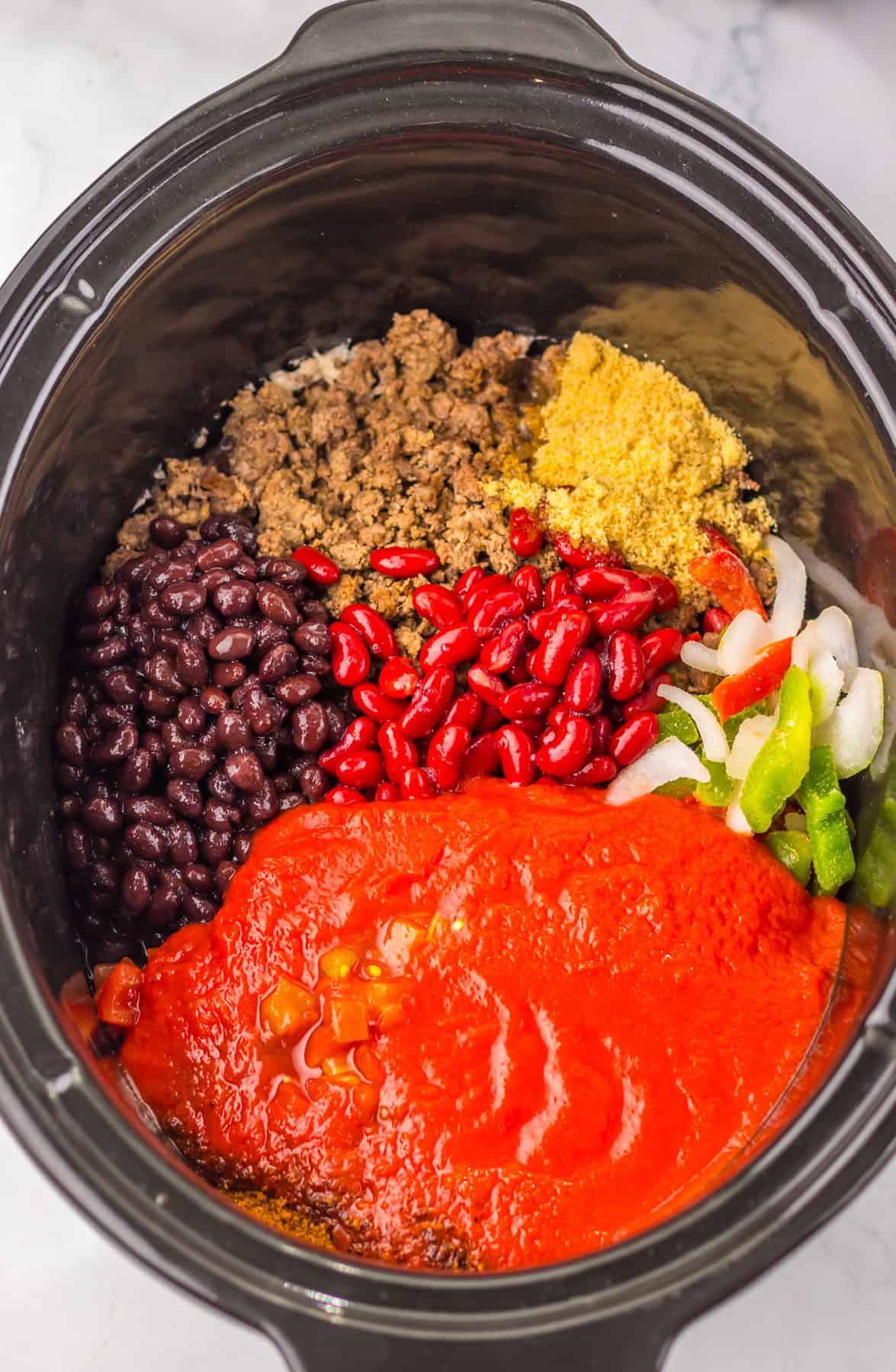 This sweet and tangy Dr. Pepper Chili is a delicious slow cooker recipe that’s perfect for a weeknight dinner. ground beef, beans, vegetables and seasonings in slow cooker