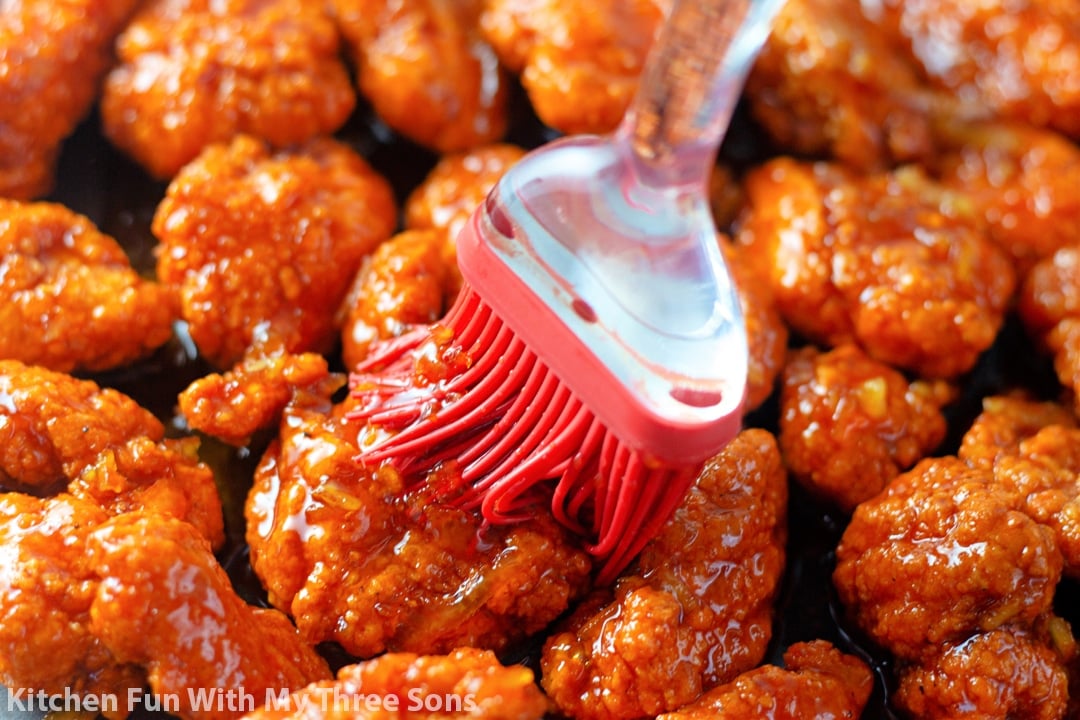 brushing orange glaze over the chicken nuggets.
