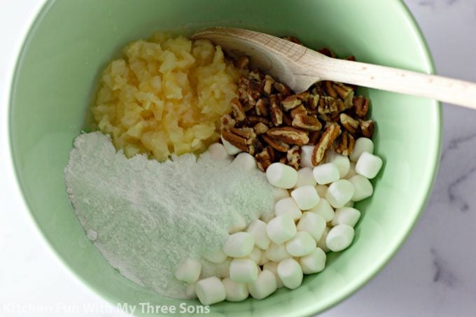 stirring together pecans, crushed pineapple, mini marshmallows, and Jello mix