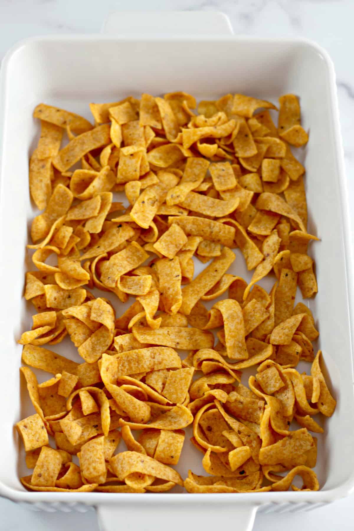 You'll love this Easy Frito Pie Recipe for a family-friendly dinner in a snap! frito chips in a baking dish