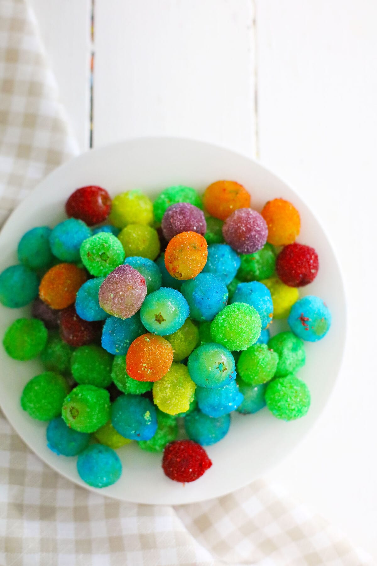 Candy Grapes are frozen grapes dipped and coated in a thin layer of vibrant and flavored Jello mix. top view of frozen jello grapes