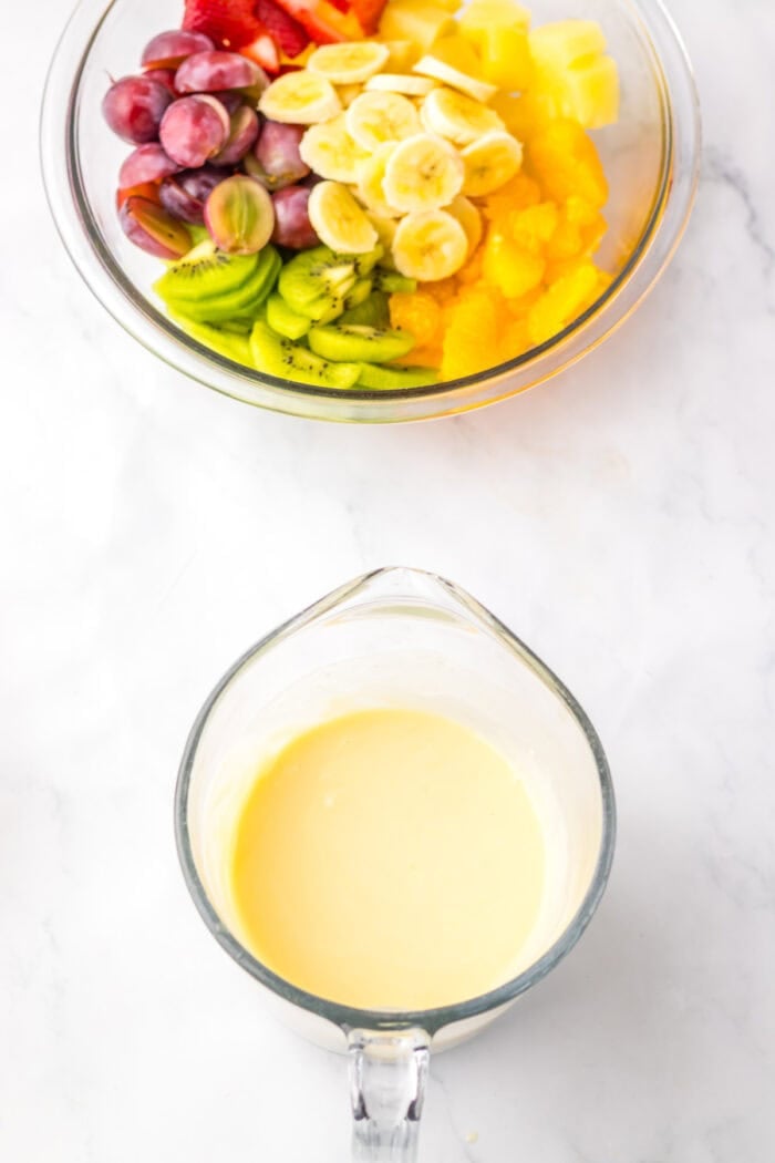 With a variety of fruit tossed in a creamy cheesecake base, this Hawaiian Cheesecake Salad is a tropical dessert perfect for summer. Cheesecake mixture in a measuring cup and a bowl of fruit