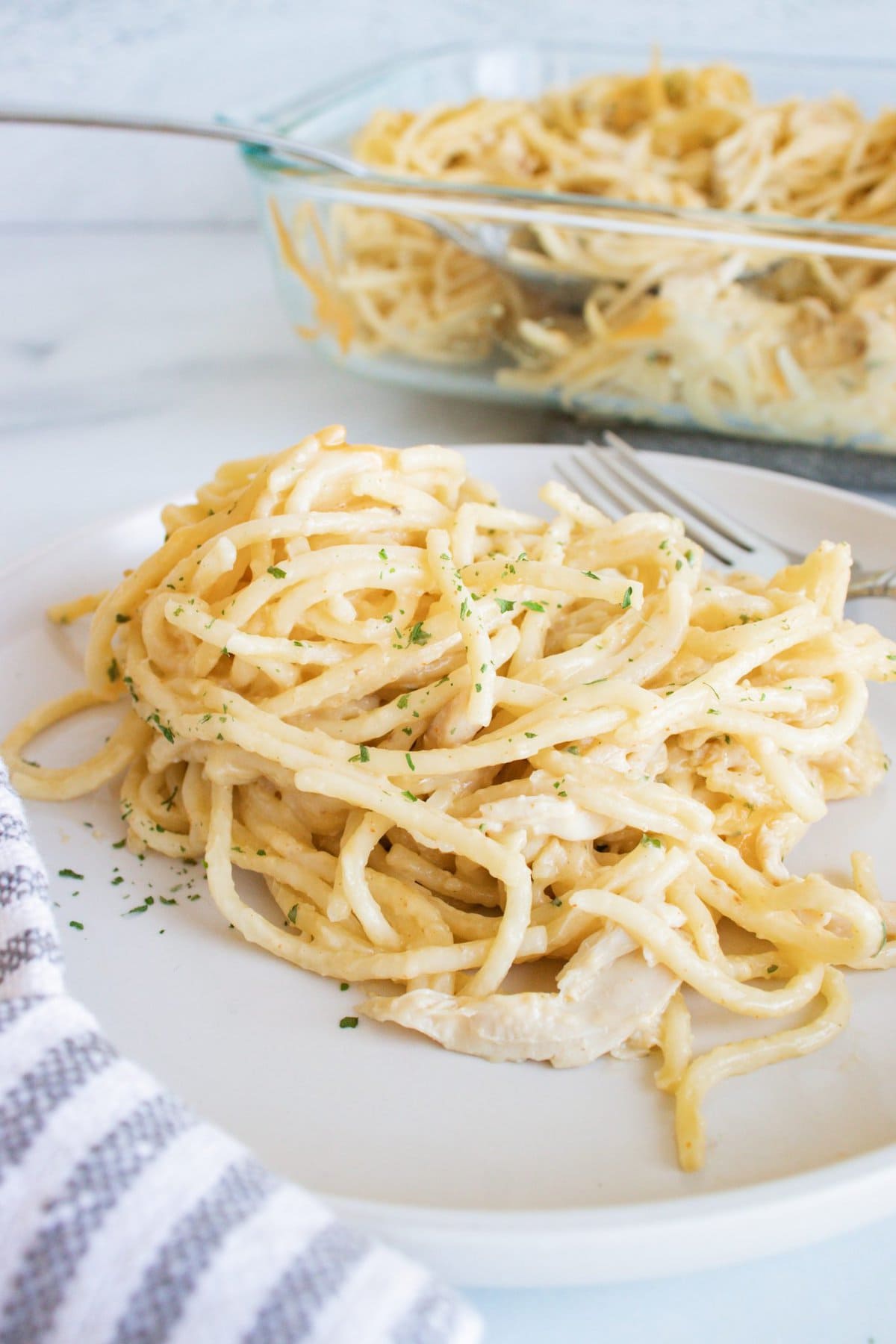 This Chicken Spaghetti Recipe is loaded with your favorite pasta flavors and uses pre-shredded or rotisserie chicken so you can have it on the table in no time. Chicken Spaghetti on a Plate