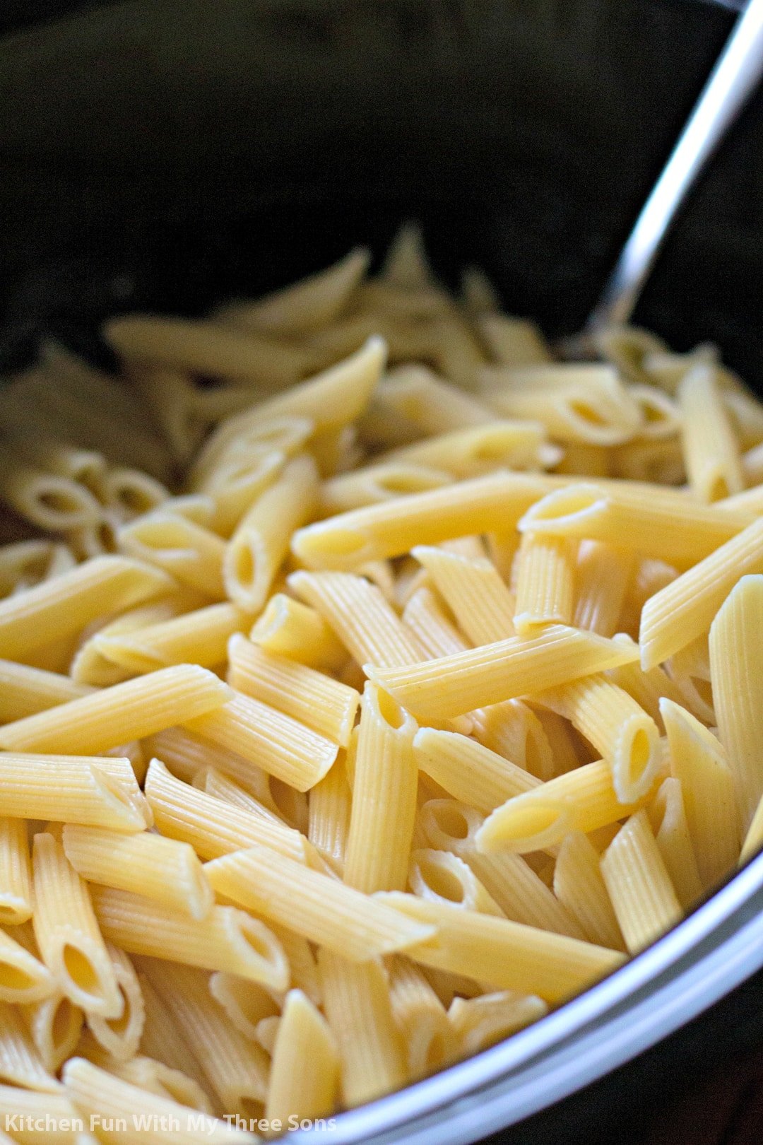 adding cooked penne to the slow cooker
