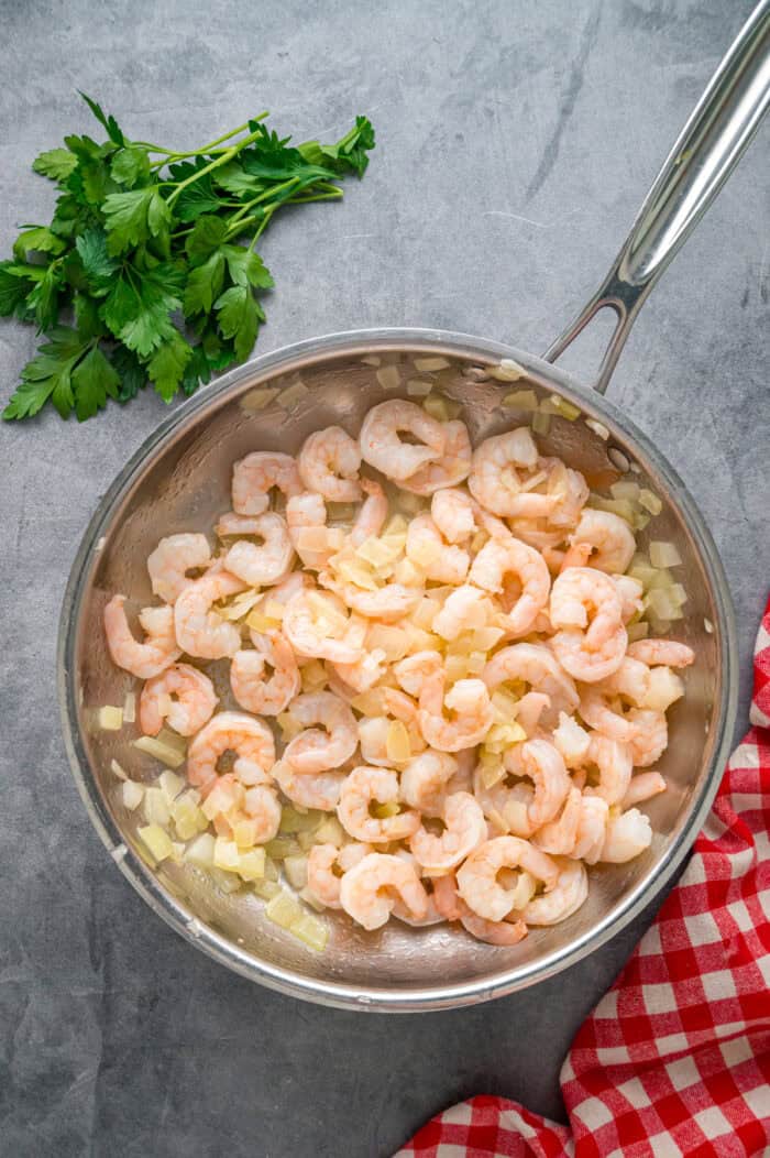 This Seafood Lasagna features layers of a creamy sauce infused with clam juice, noodles, and a shrimp and crab meat filling. Shrimp in a pan