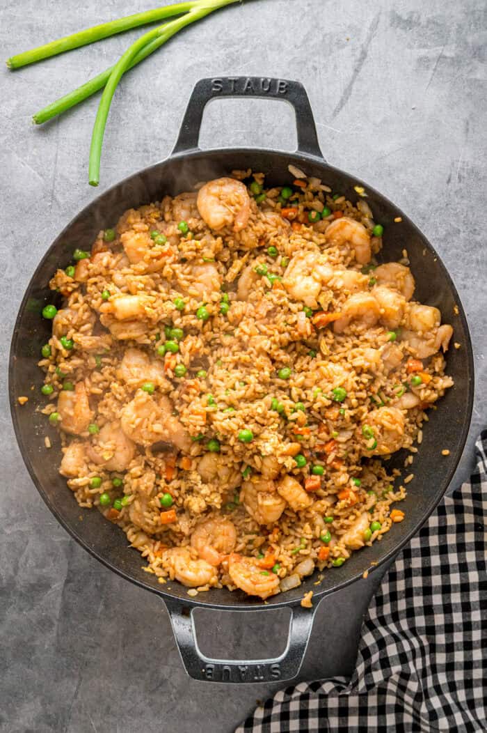 With juicy shrimp, veggies, and scrambled egg, this Shrimp Fried Rice recipe is better than takeout! Ready in just 30 minutes! A skillet of shrimp fried rice